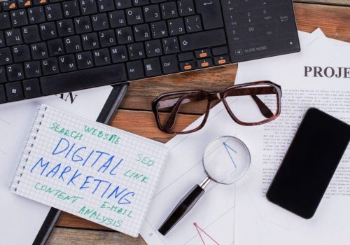 digital-marketing-on-notepad-and-various-business-2023-11-27-05-18-07-utc-w1080-h1920 Digital marketing and other information written on papers and a laptop.